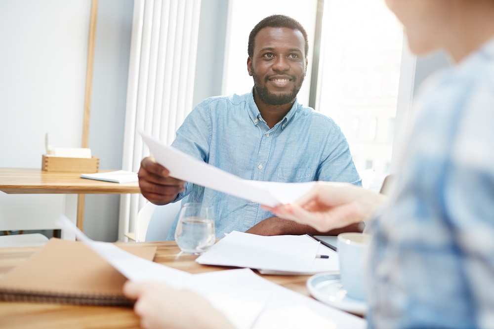 Homme tendant un contrat à un autre homme