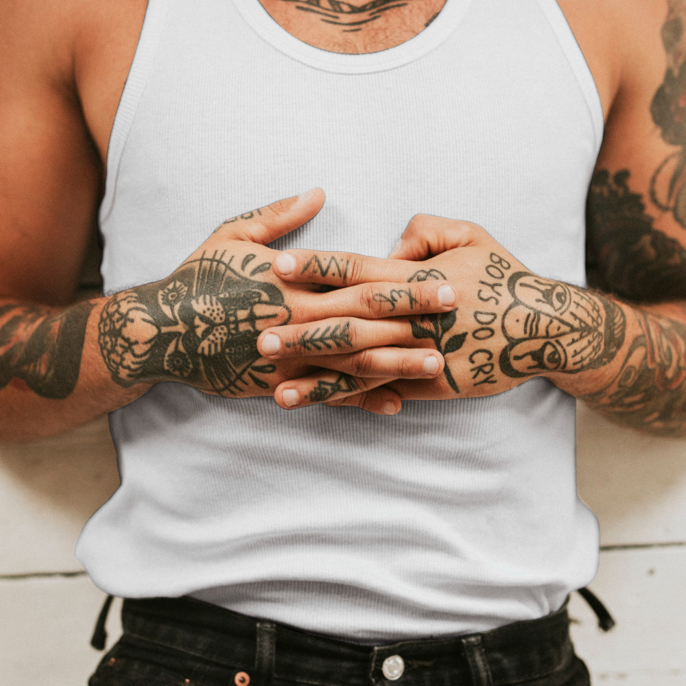 un homme avec des tatouages sur les mains