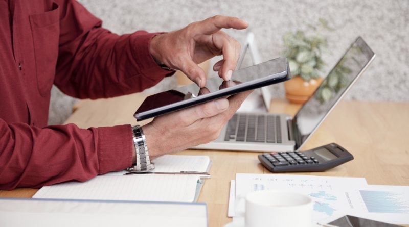 un homme au travail travaillant sur une tablette mobile