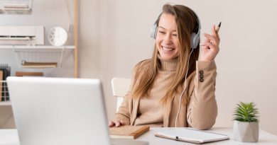 une jeune femme suivant une formation en ligne en rigolant devant son ordinateur