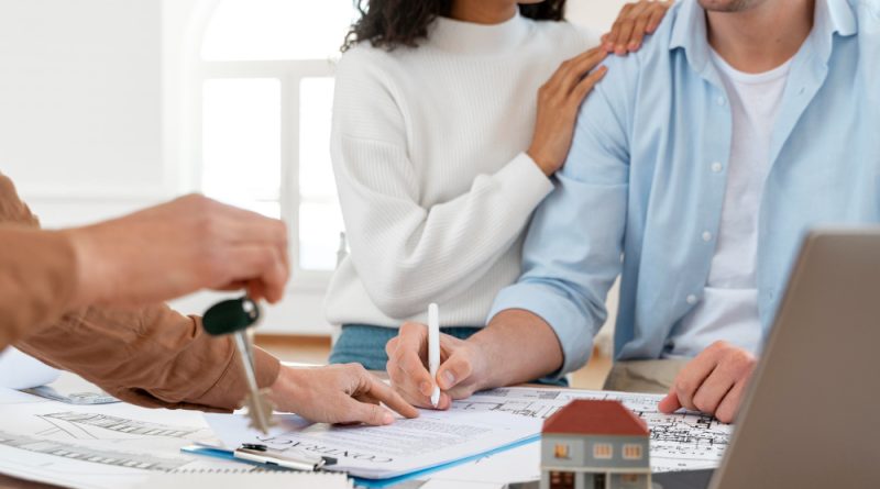 une personne travaillant dans l'immobilier faisant signer des papiers à un couple