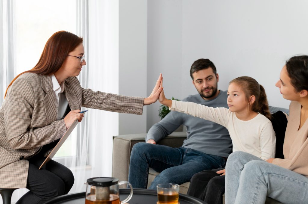 deux parents avec leur petite fille pendant une séance de médiation familiale avec un médiateur.