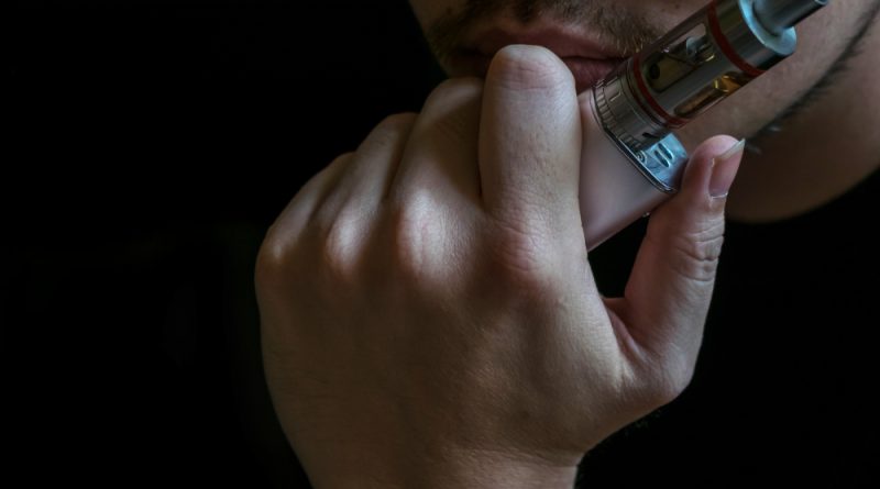 un homme tenant une ecigarette