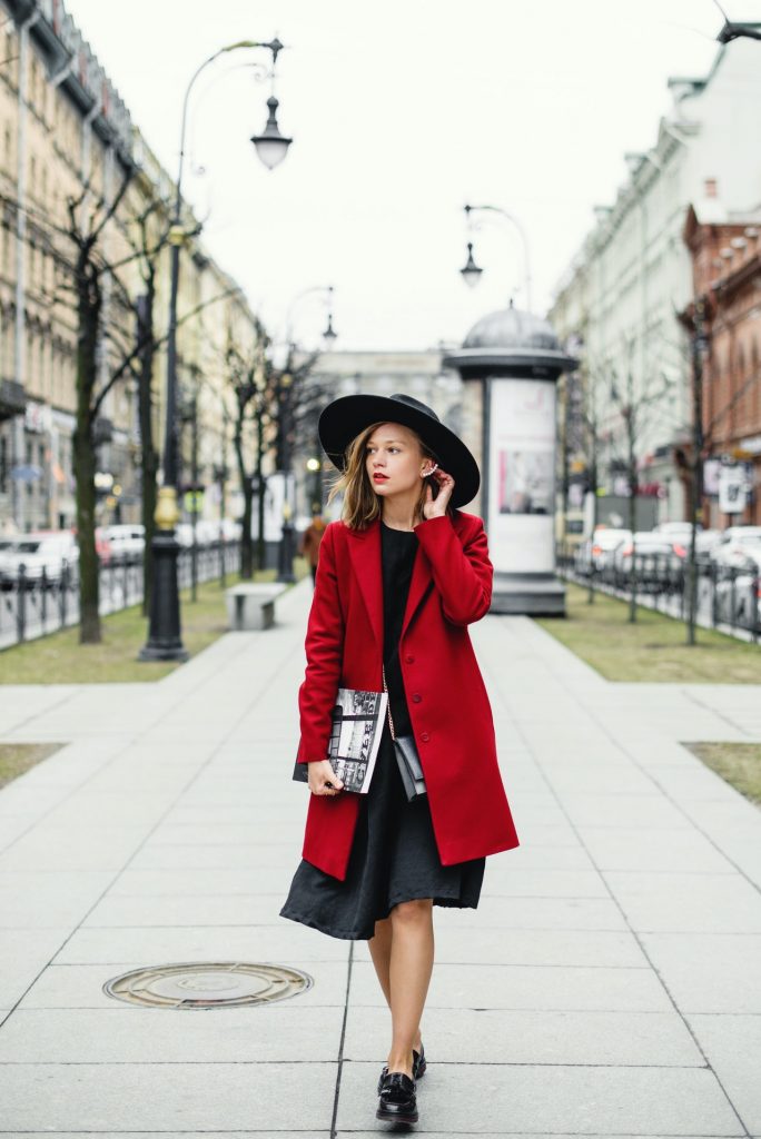 Une femme en robe longue et manteau rouge