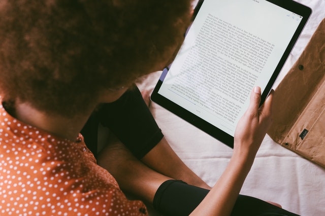 Une personne lisant un livre électronique.