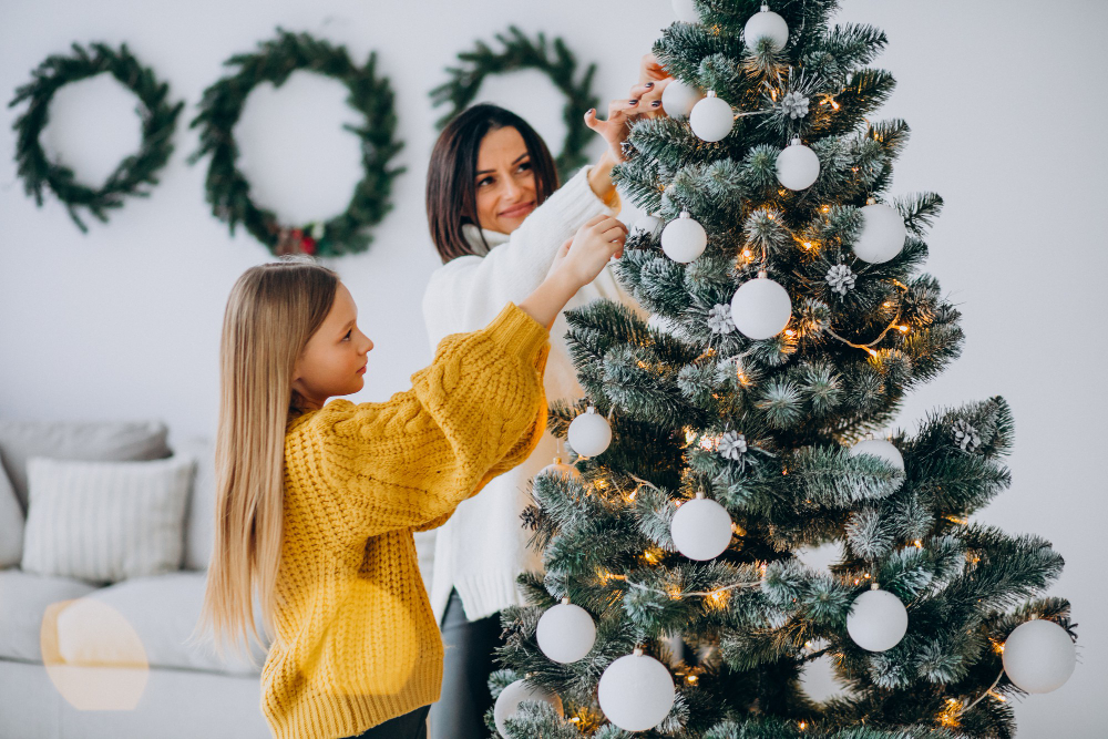 mère et fille qui décor un sapin de noël