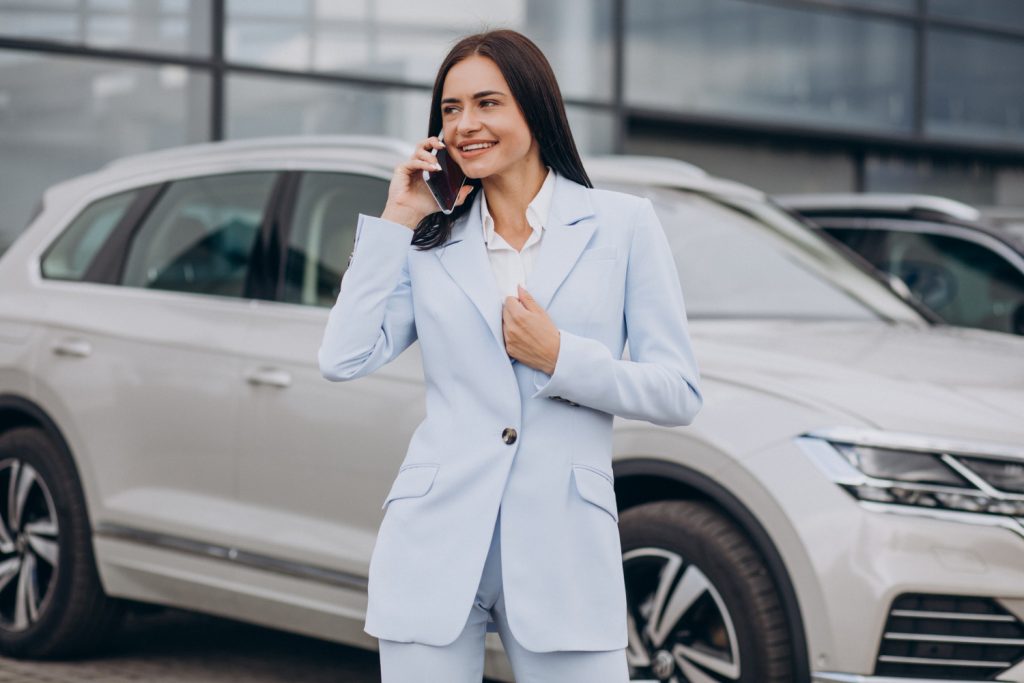 femme au téléphone devant une voiture