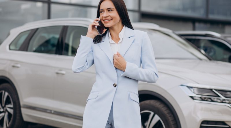 femme au téléphone devant une voiture