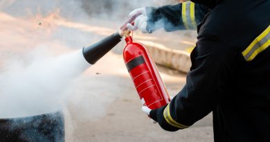 Homme éteignant un feu avec un extincteur