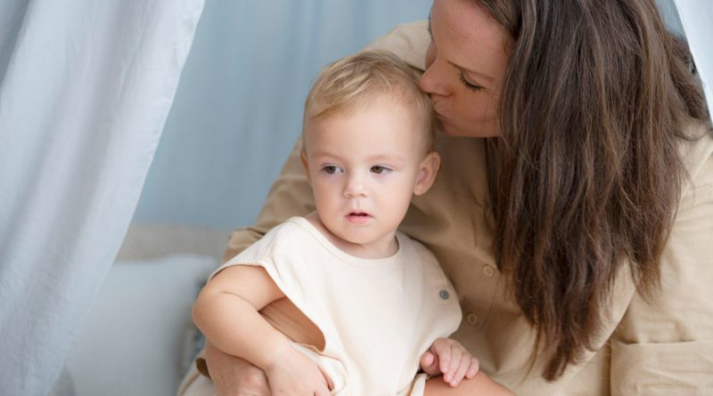 maman qui tient son fils en photo et lui embrasse la tete