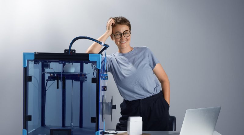 femme qui s'appui sur une imprimante 3D