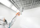 homme qui met de la peinture sur une voiture