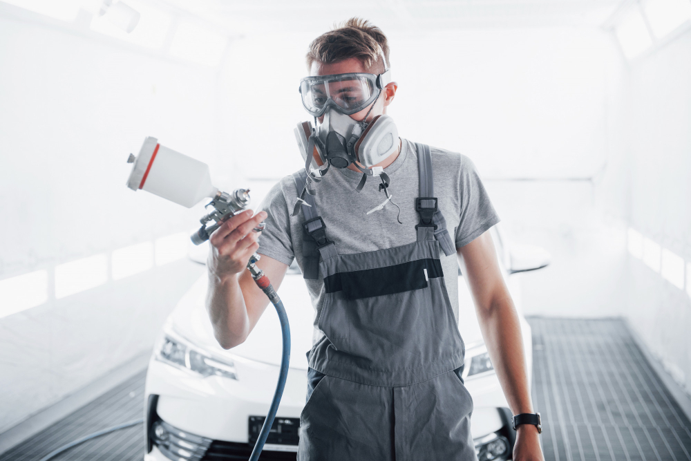 homme avec un pistolet à peinture pour voiture