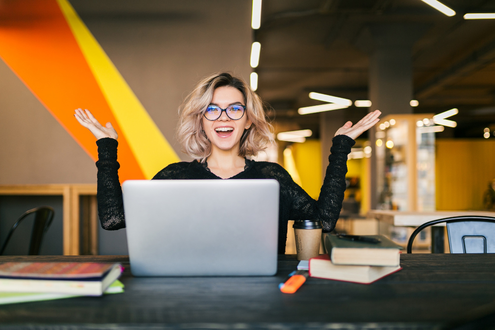 Une jeune femme souriante devant son ordinateur portable