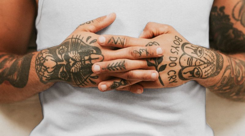 un homme avec des tatouages sur les mains