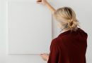 une femme accrochant un tableau blanc