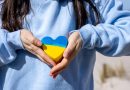 une femme montrant un mini coeur aux couleurs de l'Ukraine