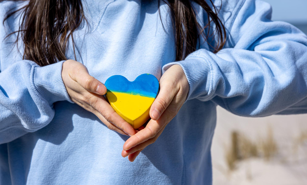 une femme montrant un mini coeur aux couleurs de l'Ukraine