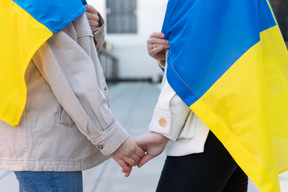 deux personnes tenant un drapeau de l'Ukraine