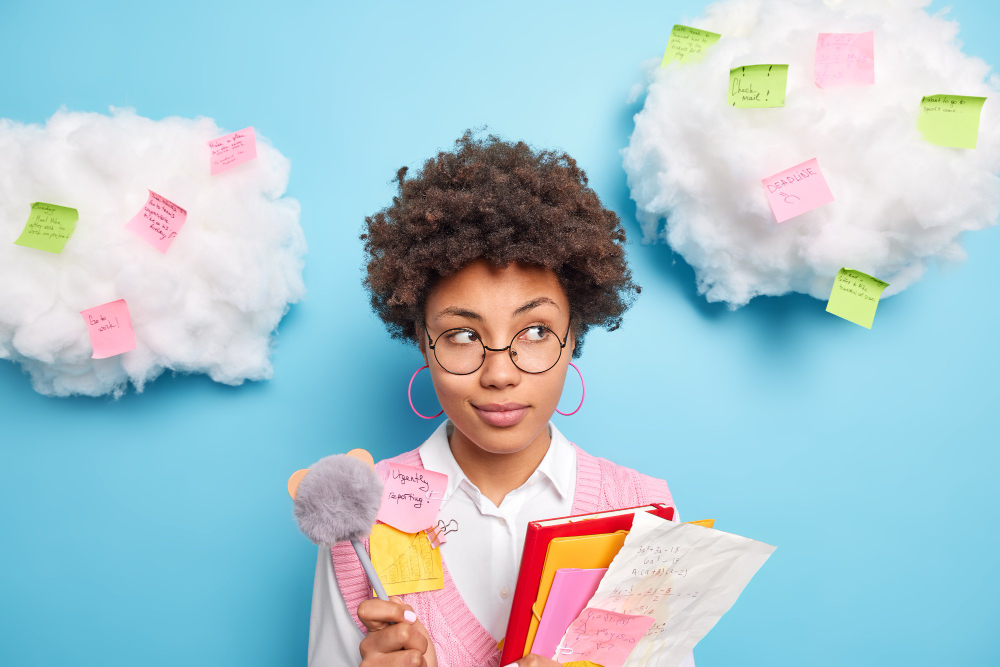 une femme devant un mur bleu avec une maquette de faux nuages remplis de post-it