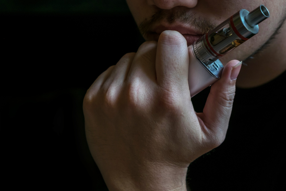 un homme tenant une ecigarette