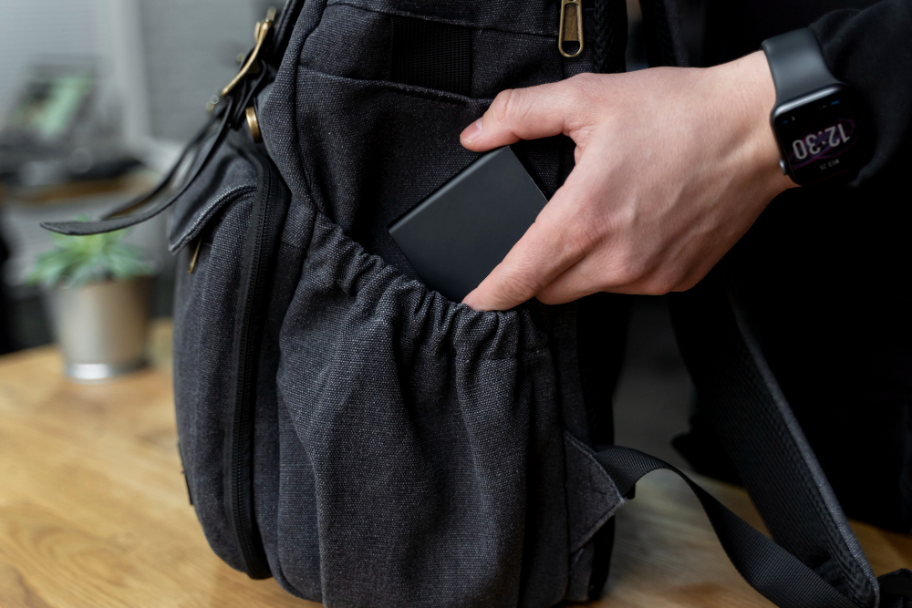 un homme mettant son téléphone dans son sac